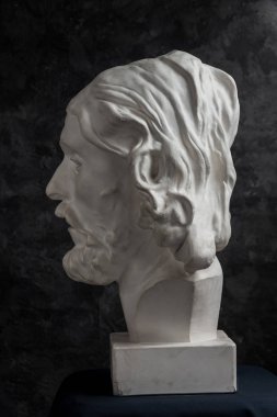 Koyu dokulu arka plan üzerinde antik heykeli John The Baptist baş Alçı kopya. Alçı heykel adam yüz.