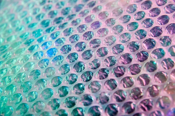 Fondo holográfico en el estilo de los 80-90. Textura real de película de envoltura de burbujas en colores ácidos brillantes . — Foto de Stock