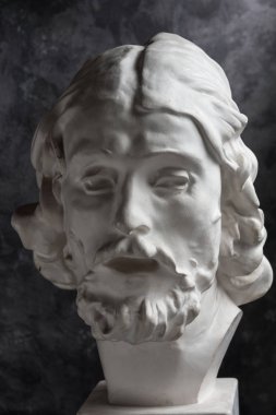 Koyu dokulu arka plan üzerinde antik heykeli John The Baptist baş Alçı kopya. Alçı heykel adam yüz.