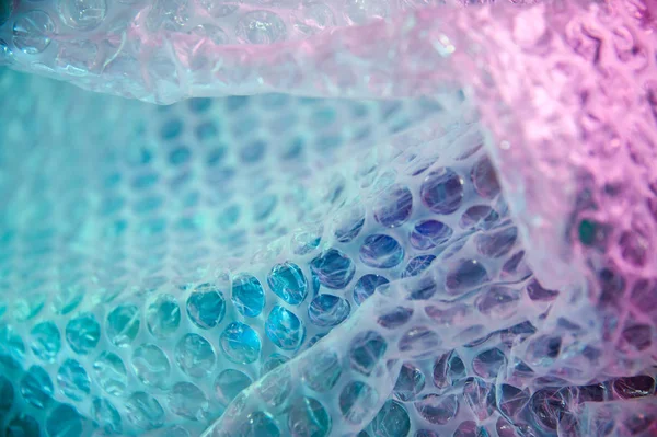 Fond holographique dans le style des années 80-90. Texture réelle du film d'enveloppe de bulle dans des couleurs acides vives . — Photo