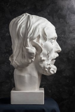 Koyu dokulu arka plan üzerinde antik heykeli John The Baptist baş Alçı kopya. Alçı heykel adam yüz.