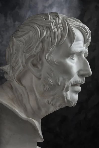 Sádrova kopie starověké sochy Seneca míří na tmavě texturované pozadí. Sádrový tvářík. — Stock fotografie