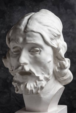 Koyu dokulu arka plan üzerinde antik heykeli John The Baptist baş Alçı kopya. Alçı heykel adam yüz.