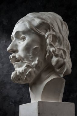 Koyu dokulu arka plan üzerinde antik heykeli John The Baptist baş Alçı kopya. Alçı heykel adam yüz.