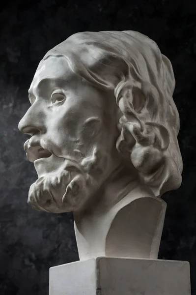 暗いテクスチャの背景にバプテスマの頭の古代の彫像ジョンの石膏のコピー。石膏彫刻男の顔. — ストック写真