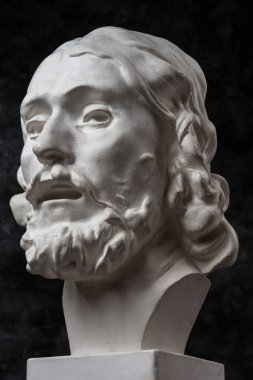 Koyu dokulu arka plan üzerinde antik heykeli John The Baptist baş Alçı kopya. Alçı heykel adam yüz.