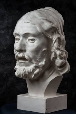 Koyu dokulu arka plan üzerinde antik heykeli John The Baptist baş Alçı kopya. Alçı heykel adam yüz.