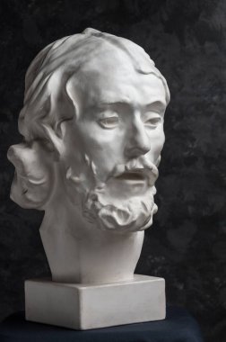 Koyu dokulu arka plan üzerinde antik heykeli John The Baptist baş Alçı kopya. Alçı heykel adam yüz.