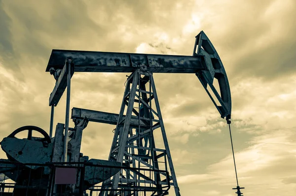 Concepto de petróleo. Plataforma de bomba de aceite. Producción de petróleo y gas. Sitio del campo petrolífero. Jack la bomba está funcionando. Drilling derricks for fossil fuels output and crude oil production. Crisis global. Guerra contra los precios del petróleo. —  Fotos de Stock