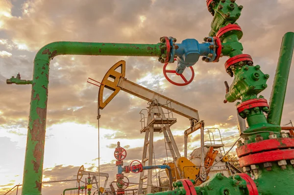 Conceito de petróleo. Equipamento de bomba de óleo. Produção de petróleo e gás. Local do campo petrolífero. O Jack da bomba está a funcionar. Derricas de perfuração para a produção de combustíveis fósseis e produção de petróleo bruto. Crise global. Guerra aos preços do petróleo. — Fotografia de Stock