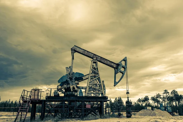 Concepto de petróleo. Plataforma de bomba de aceite. Producción de petróleo y gas. Sitio del campo petrolífero. Jack la bomba está funcionando. Drilling derricks for fossil fuels output and crude oil production. Crisis global. Guerra contra los precios del petróleo. — Foto de Stock