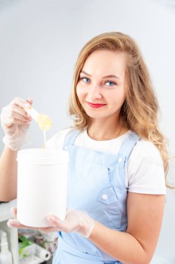 Güzellik salonunda şeker ve balmumu tüy dökücü ayaklar. Bacaklardaki kıllardan kurtul. Şekerleme. Kozmetik uzmanı bacaklarındaki kılları alıyor. Spa merkezinde güzellik uzmanı. Kozmetoloji kavramı.