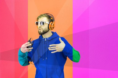 Gözlüklü, kulaklıklı, sakallı hippi dans ediyor ve akıllı telefonuyla zevkli müzikler dinliyor. Aşk canlı. Boş zaman hobisi konsepti. Rahatla..