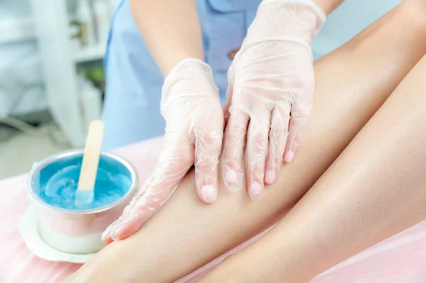 Suiker en ontharing van de voeten in de schoonheidssalon. Ontdaan van haar op de benen. Suiker. Meester cosmetoloog verwijdert haar op de benen. Schoonheidsspecialiste in het kuuroord. Cosmetologisch concept. — Stockfoto