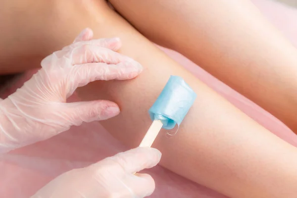 Zucchero e ceretta depilazione dei piedi nel salone di bellezza. Sbarazzarsi di capelli sulle gambe. Zucchero. Master cosmetologo rimuovere i peli sulle gambe. Estetista nel centro benessere. Concetto cosmetologico. — Foto Stock