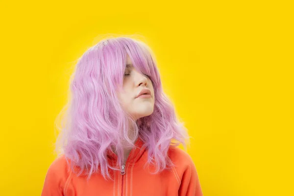 Close up ritratto di moda bella giovane donna con i capelli rosa su sfondo giallo. Copia spazio. — Foto Stock