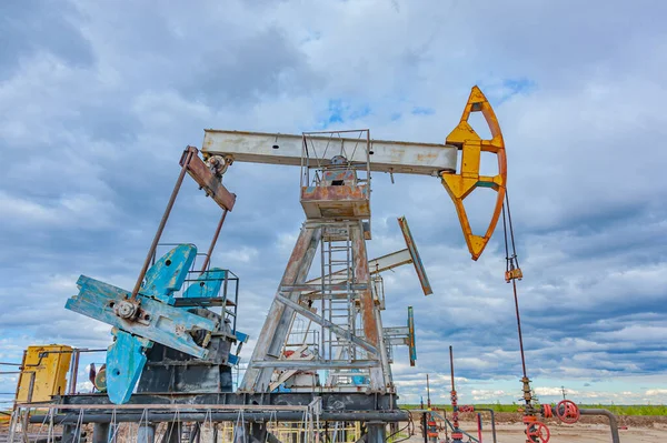 Petroleumkoncept. Oljepumpsrigg. Olje- och gasproduktion. Oljefält. Pump Jack springer. Borrkranar för produktion av fossila bränslen och råolja. Global kris. Krig mot oljepriserna. — Stockfoto