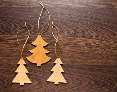 Ahşap zemin üzerinde üç el yapımı Noel ağaçları. Noel süsleri, oyuncak, hediye ya da Hatıra Eşyası. Metin için yer