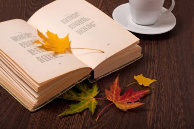 Kahve, kitap ve Sonbahar Kupası tahta masada bırakır. Sonbahar konsepti.