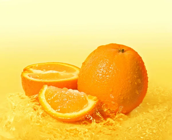 Orange fruits and juice splash — Stock Photo, Image
