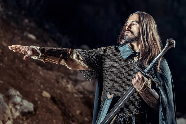 Langhaariger Ritter Mit Dem Zweihändigen Schwert Felsen Hintergrund — Stockfoto