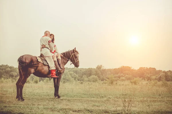 Maturo uomo e donna in abiti etnici stanno per fare una passeggiata a cavallo — Foto Stock