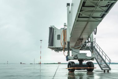 Havaalanında teleskopik merdiven. Yağmurlu arka plan.