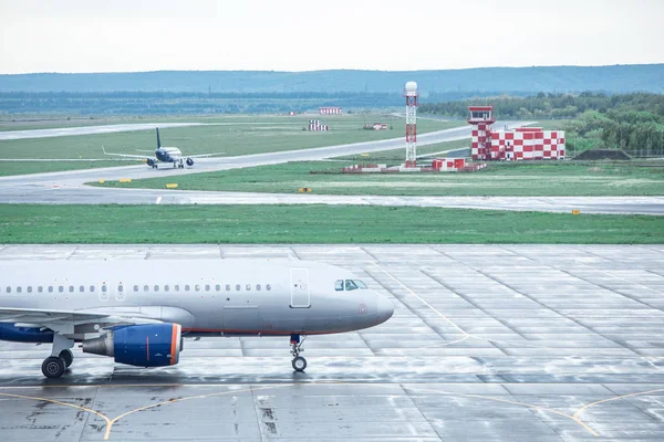 Two modern unrecognizable planes are on the runway at the airport — Stock Photo, Image