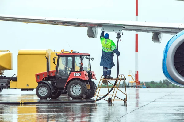 Aircraft refueling at the airport. Fuel tank and tractor on the background. — Stock Photo, Image
