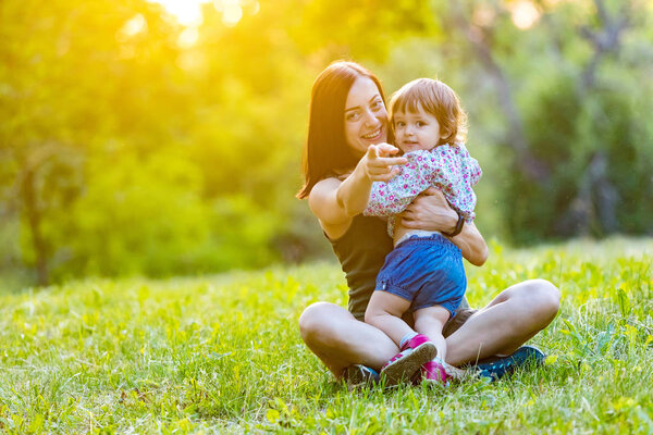 Mother and daughter having fun in the park. Happy family concept