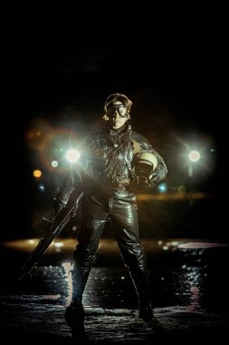 Deri elbiseli, silahlı güzel kadın asker.