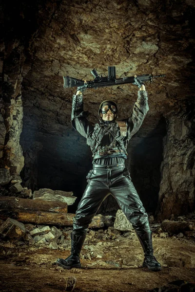 Παραδοτέα γυναίκα στρατιώτης με δερμάτινα ρούχα με το όπλο. — Φωτογραφία Αρχείου