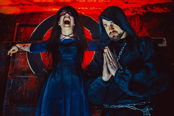 Betender Mönch neben angeketteter Hexe im Inquisitionsverlies — Stockfoto