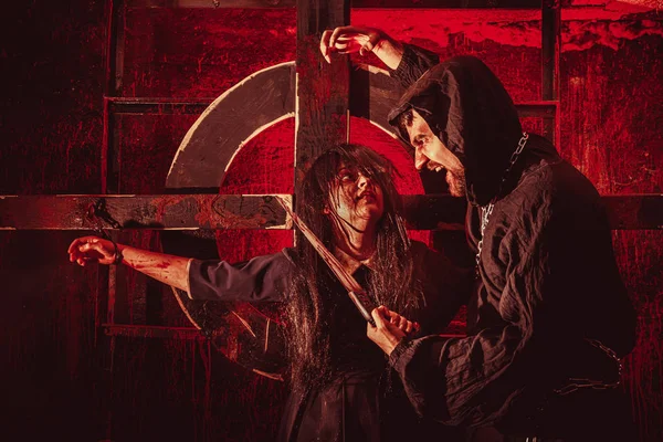 Scary maniac with the saw prepares to kill his female victim — Stock Photo, Image