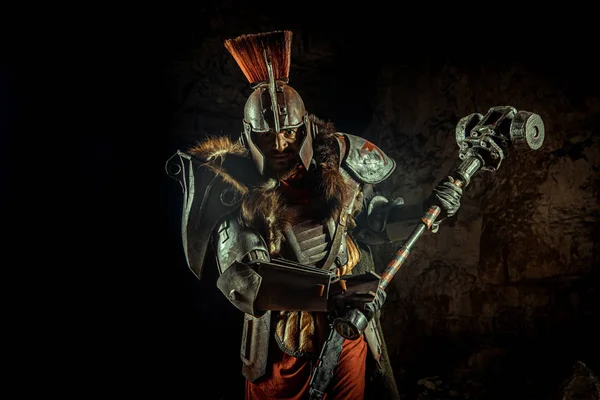 一个身披盔甲、身披铁锤的骑士的袭击 以地下城为背景. — 图库照片