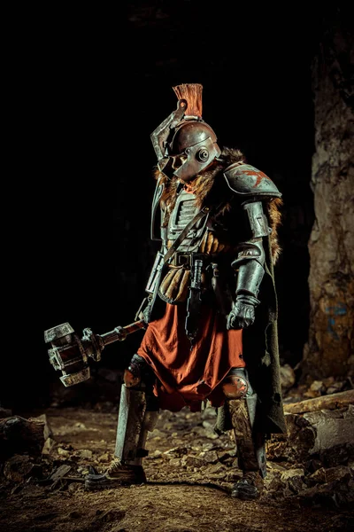 强大的骑士拿着铁锤在盔甲里 以地下城为背景. — 图库照片