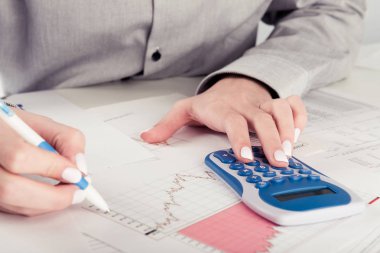kadın yönetmen ofiste çalışan iş istatistikleri, hesap makinesi, diyagramlar ve grafikler masa üzerine analiz 