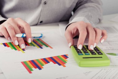 kadın yönetmen ofiste çalışan iş istatistikleri, hesap makinesi, diyagramlar ve grafikler masa üzerine analiz 