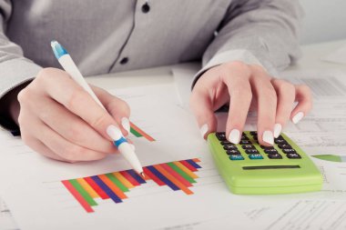 kadın yönetmen ofiste çalışan iş istatistikleri, hesap makinesi, diyagramlar ve grafikler masa üzerine analiz 