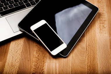 ahşap masa üzerinde telefon ve tablet pc ile dizüstü klavye