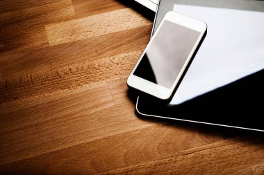 ahşap masa üzerinde telefon ve tablet pc ile dizüstü klavye