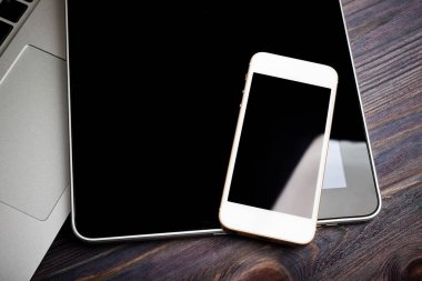 ahşap masa üzerinde telefon ve tablet pc ile dizüstü klavye