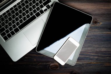ahşap masa üzerinde telefon ve tablet pc ile dizüstü klavye