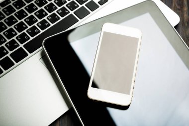 ahşap masa üzerinde telefon ve tablet pc ile dizüstü klavye