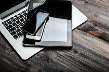 Klavyeyle mevcut iki telefonları ve tablet pc ahşap masa üzerinde