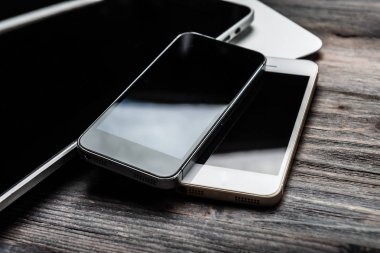 Klavyeyle mevcut iki telefonları ve tablet pc ahşap masa üzerinde