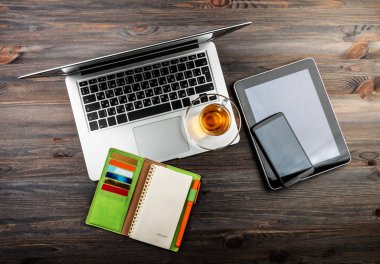 Ofis büro dizüstü bilgisayar, tablet pc, planlayıcısı, kalem, hareket eden smartphone ve çay ile