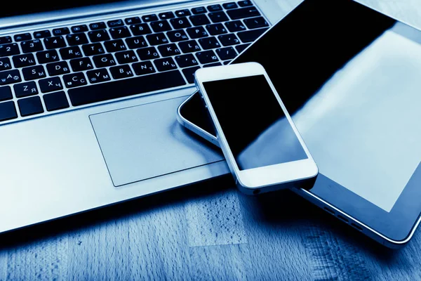 键盘与电话和平板电脑在木桌上 蓝色色调 — 图库照片