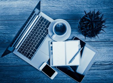 Ofis büro dizüstü bilgisayar, tablet pc, planlayıcısı, kalem, hareket eden smartphone ve fincan çay, mavi tonu ile