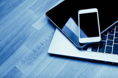 ahşap masa, mavi telefon ve tablet pc ile klavye tonda